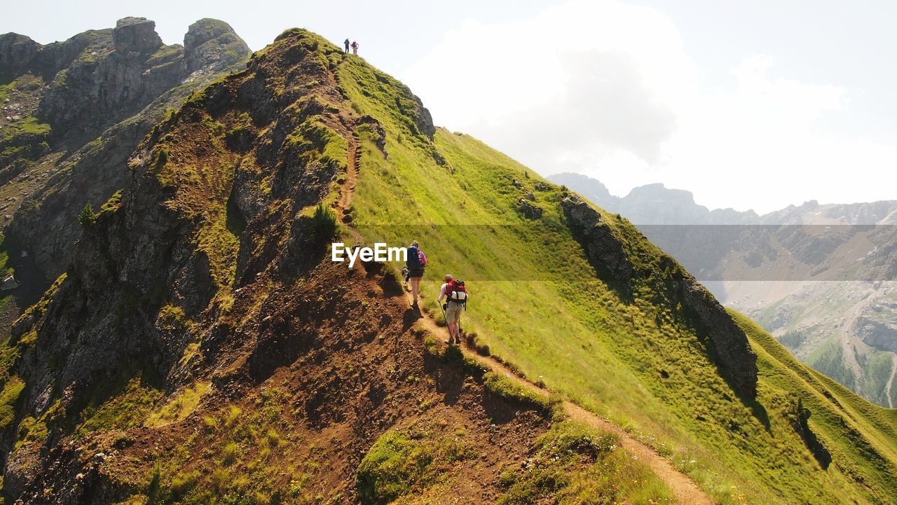 PEOPLE ON MOUNTAINS AGAINST SKY