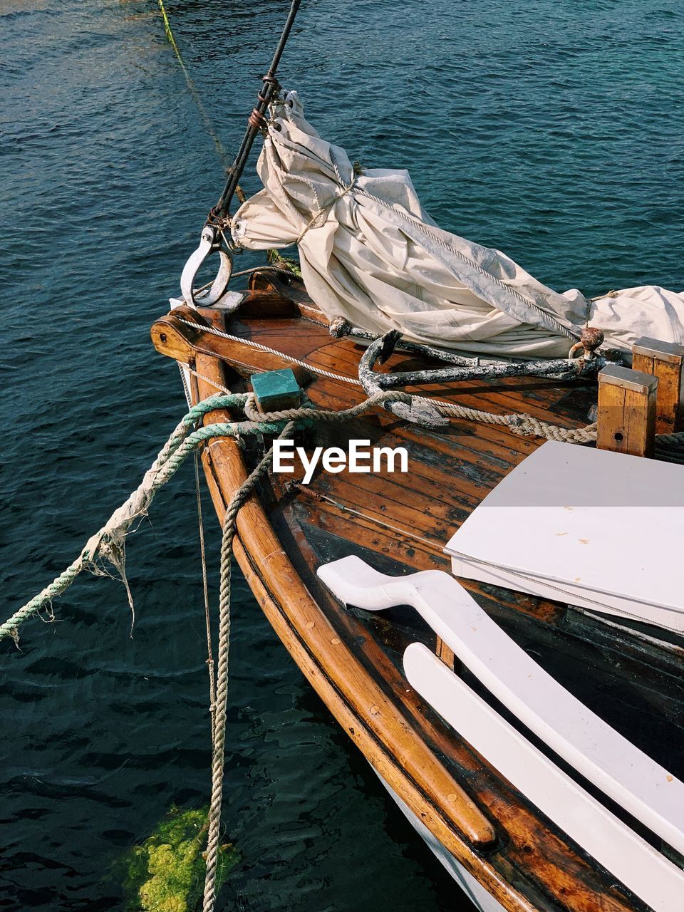 High angle view of fishing boat sailing in sea, wooden deck, ropes, accessories, sunny day 