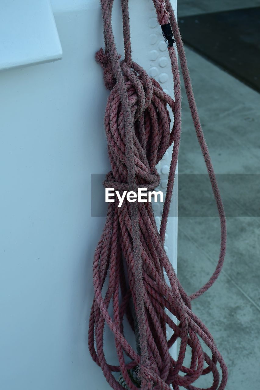 CLOSE-UP OF ROPE TIED TO METAL