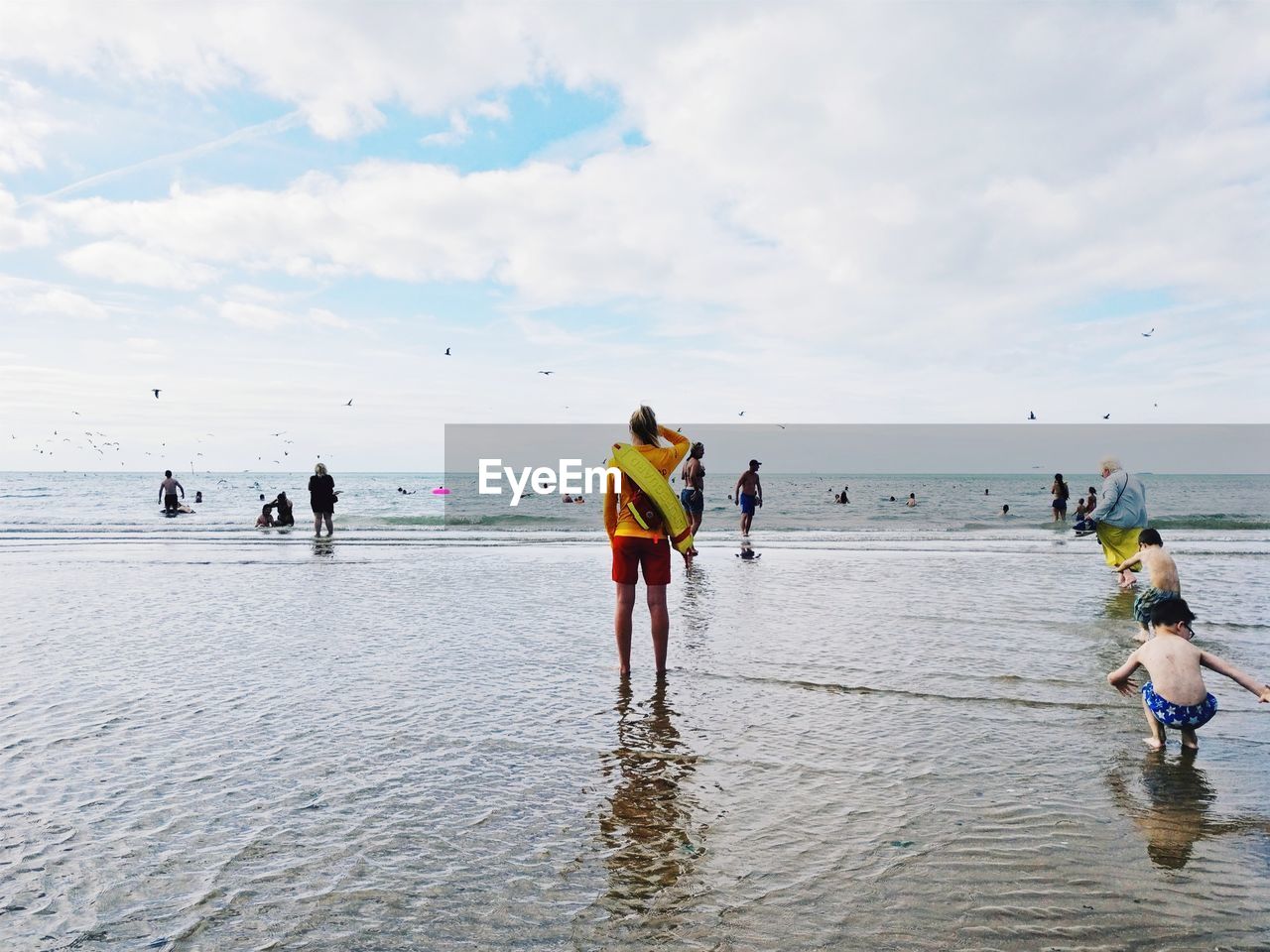 PEOPLE AT BEACH AGAINST SKY