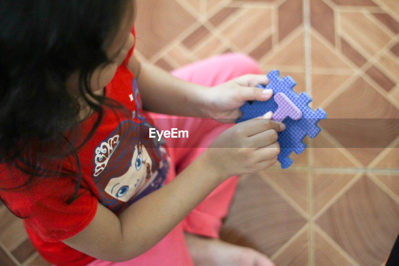 High angle view of girl playing with toy at home