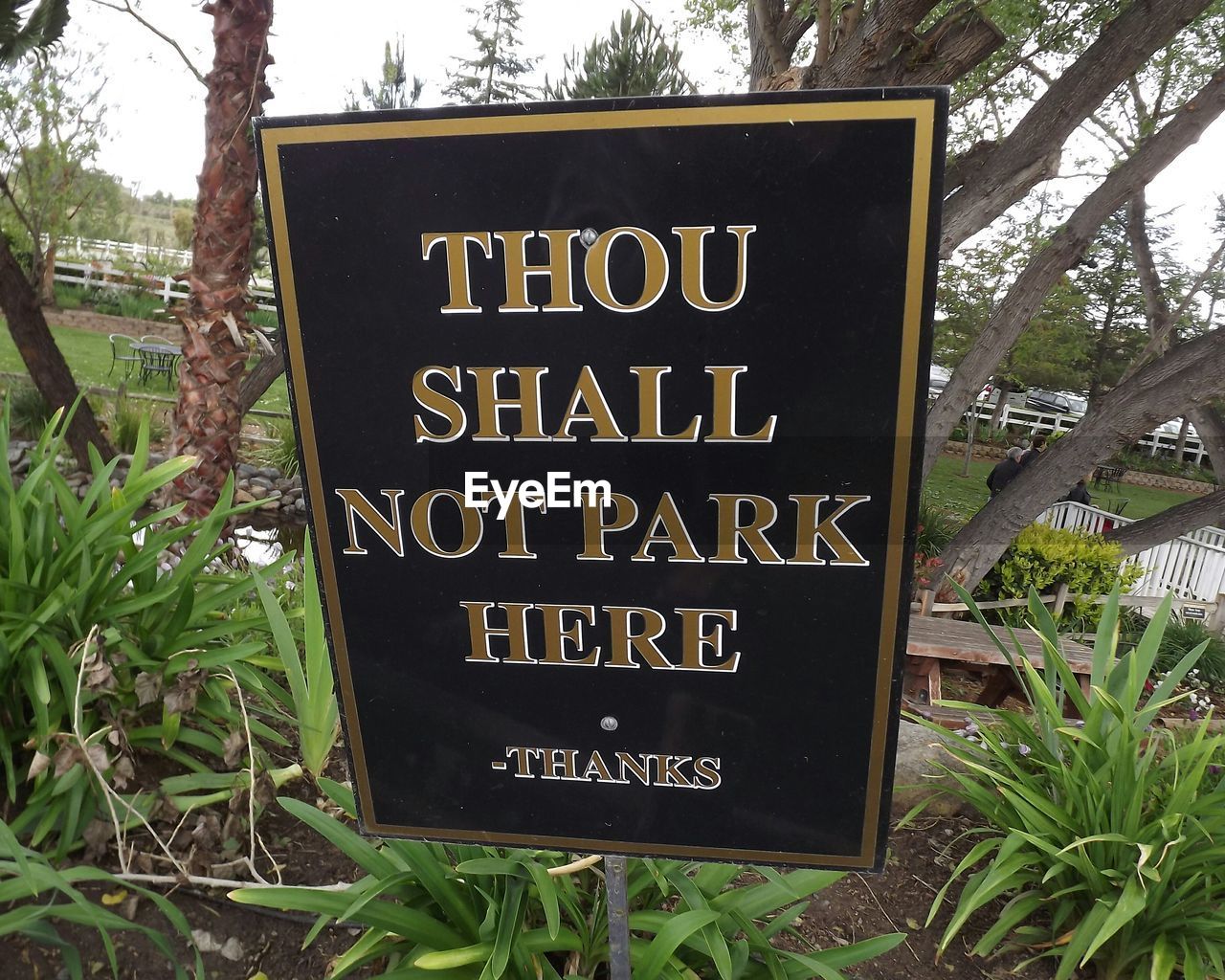 Information sign in garden against sky