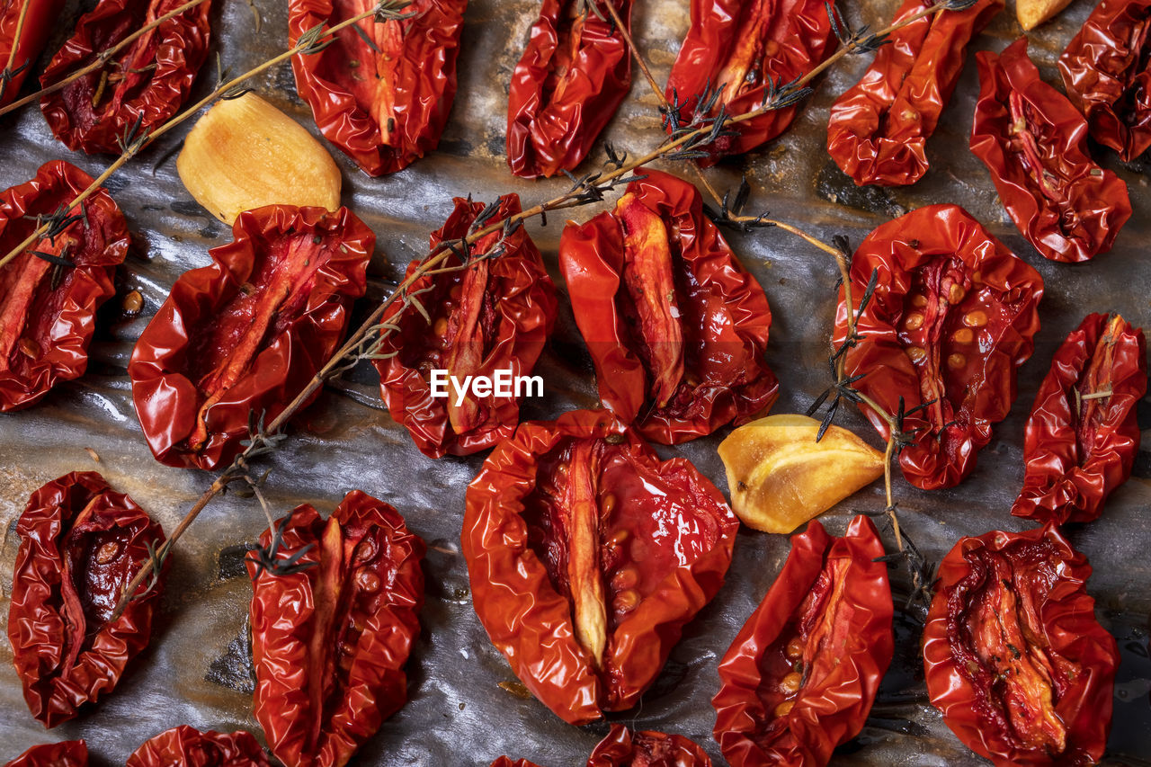 Close-up top view oven-roasted sundried tomatoes on a baking sheet on parchment paper