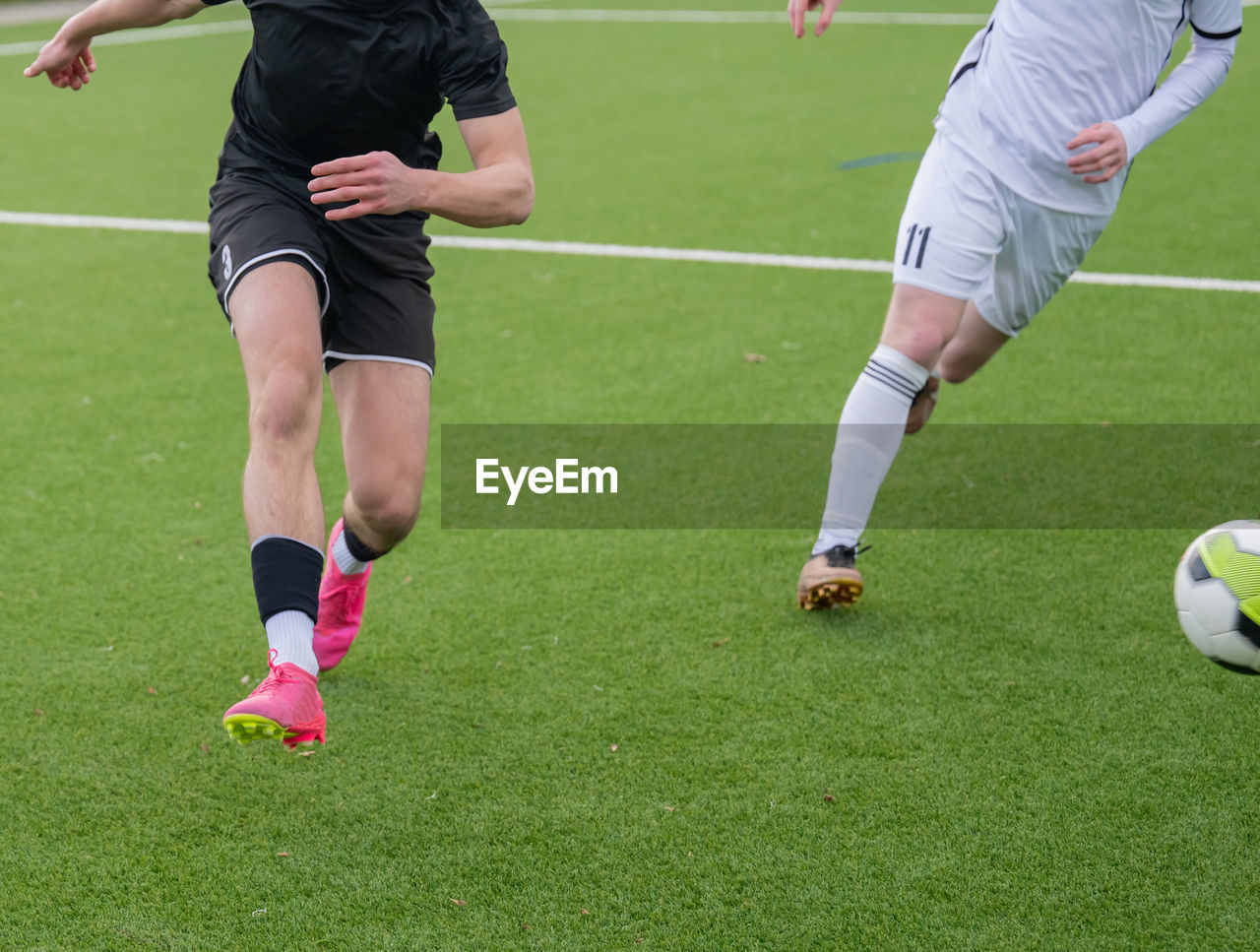 full length of man playing soccer at park