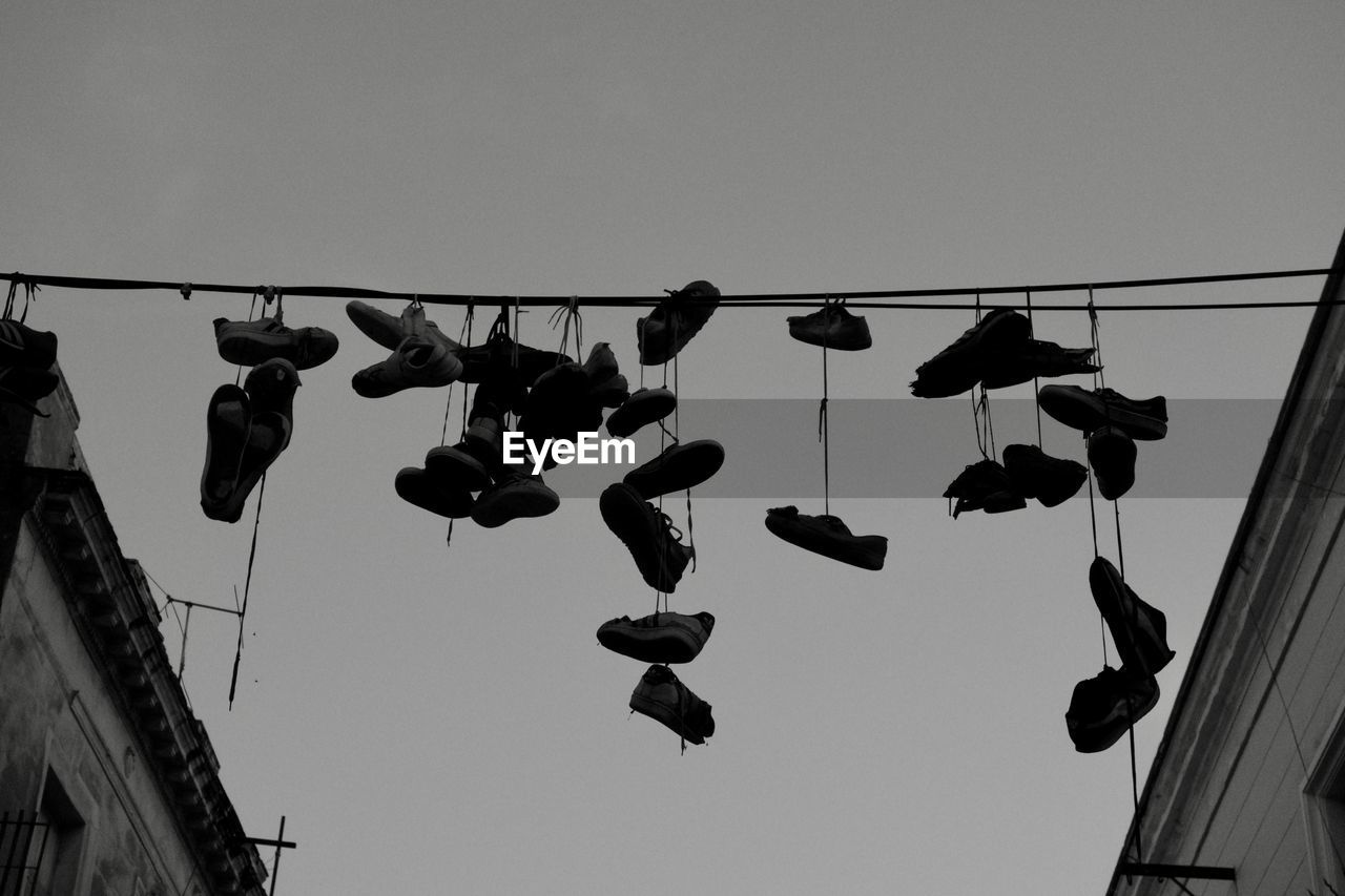 LOW ANGLE VIEW OF SHOES AGAINST SKY