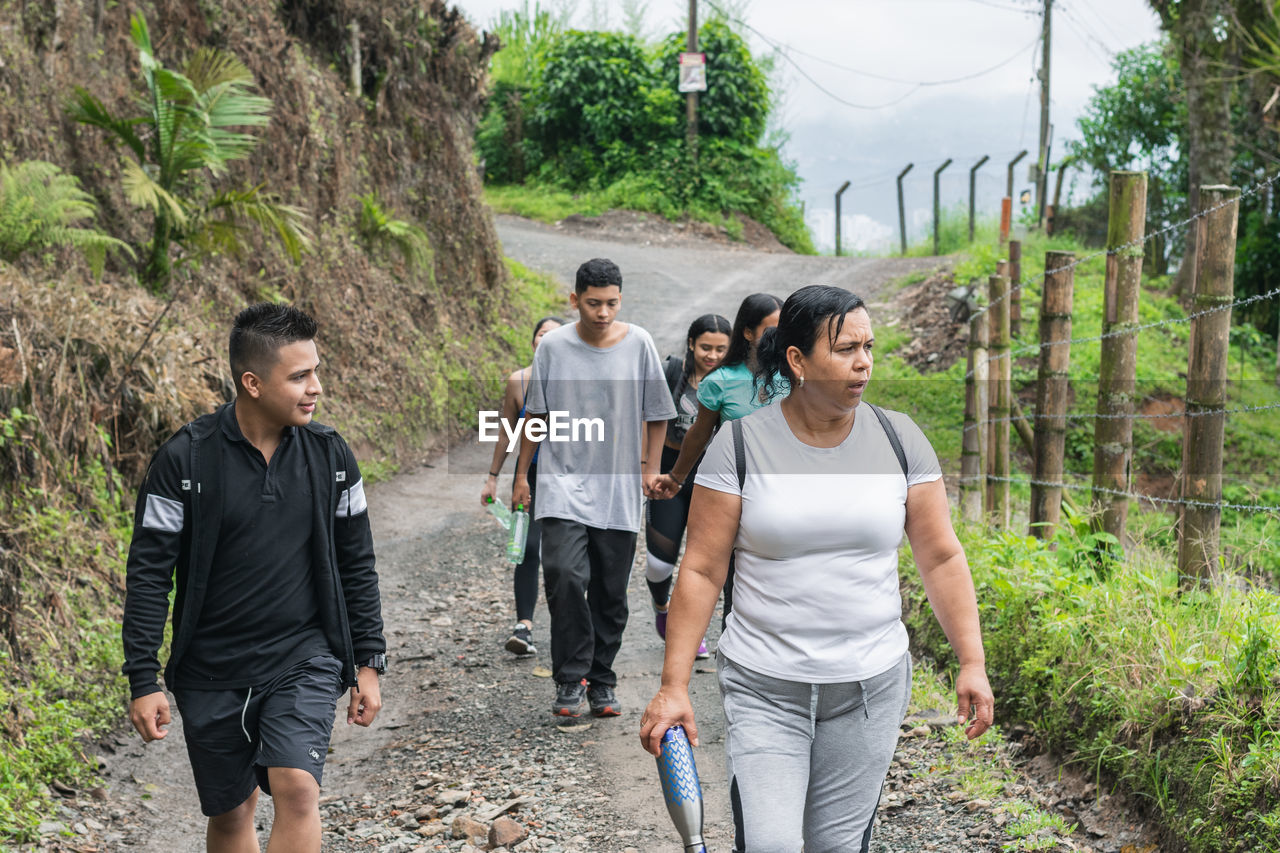 Group of people hiking high up in the colombian mountains. family out for a walk on a dirt trail