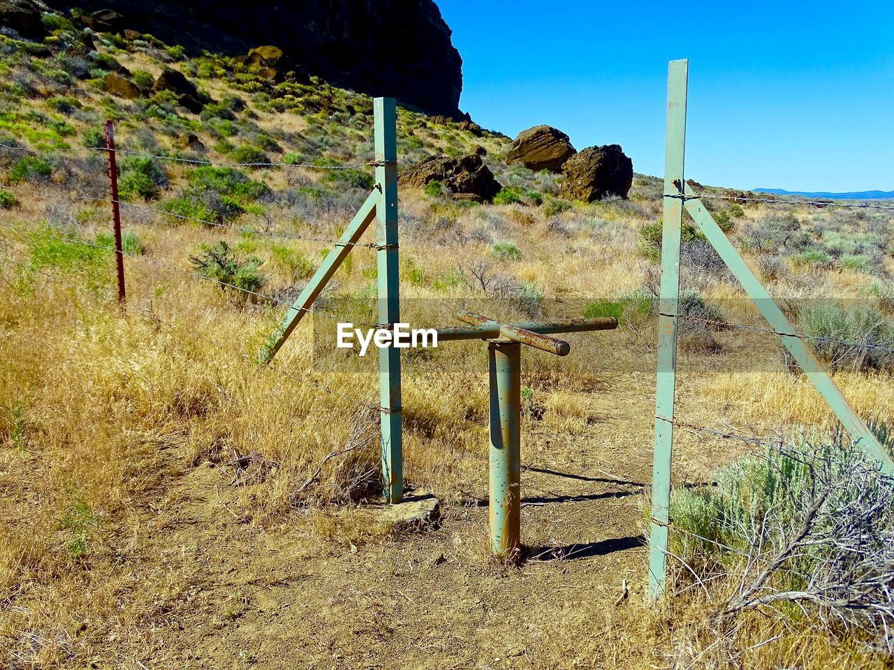 Wooden post on field against clear sky