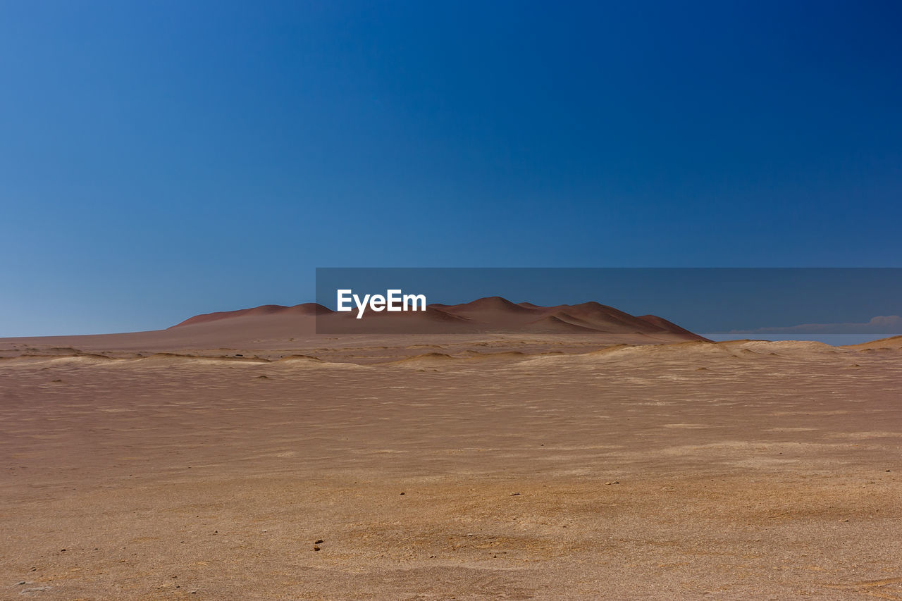 View of desert against blue sky