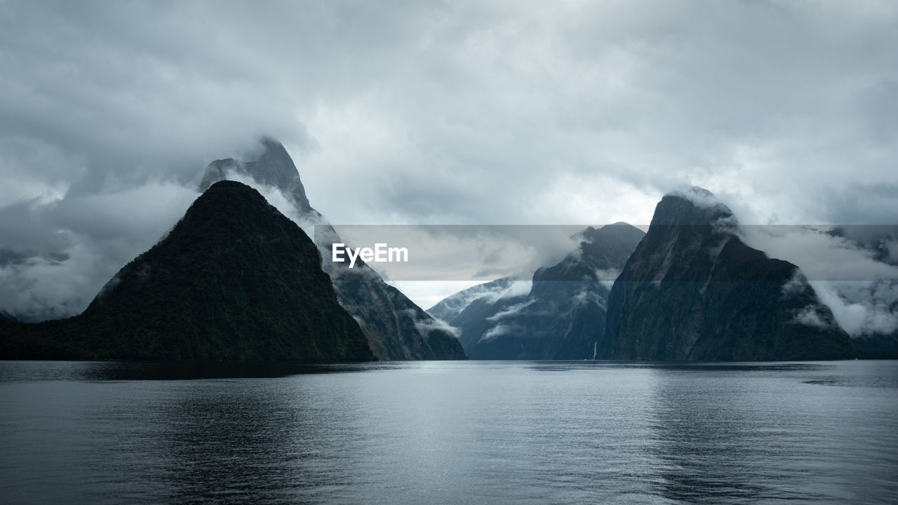 Scenic view of lake by mountains against sky