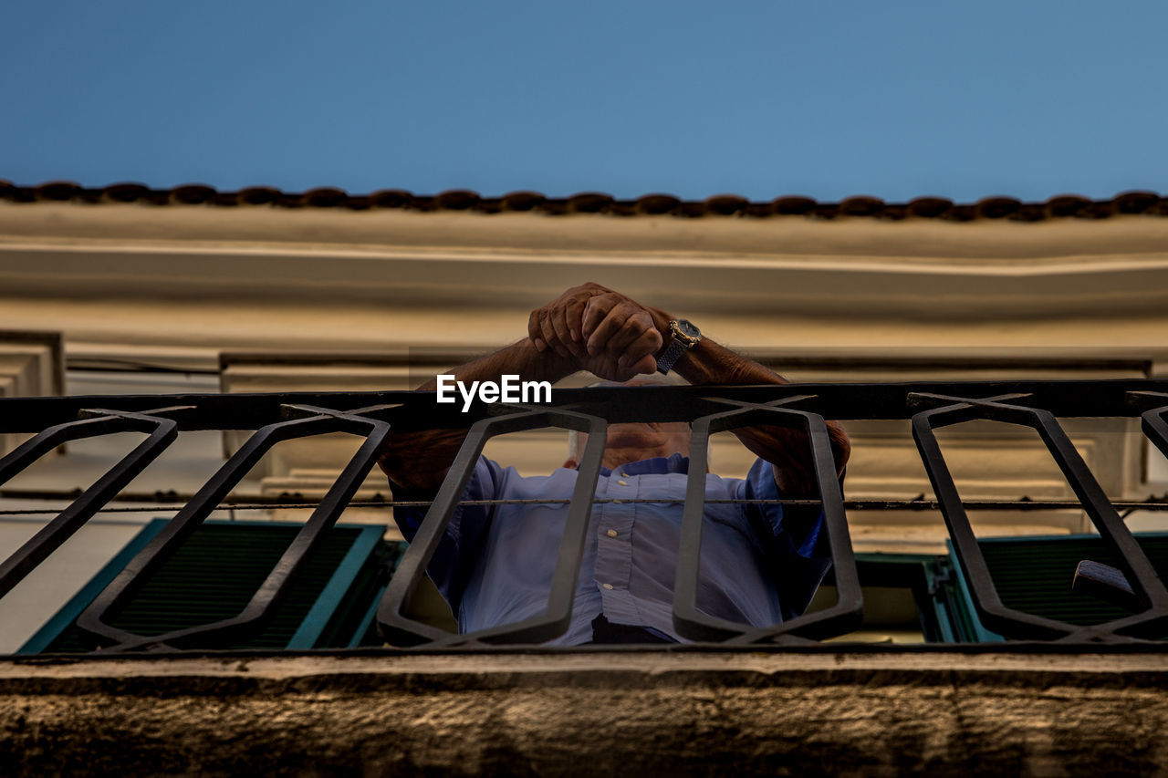 Low angle view of senior man standing in balcony