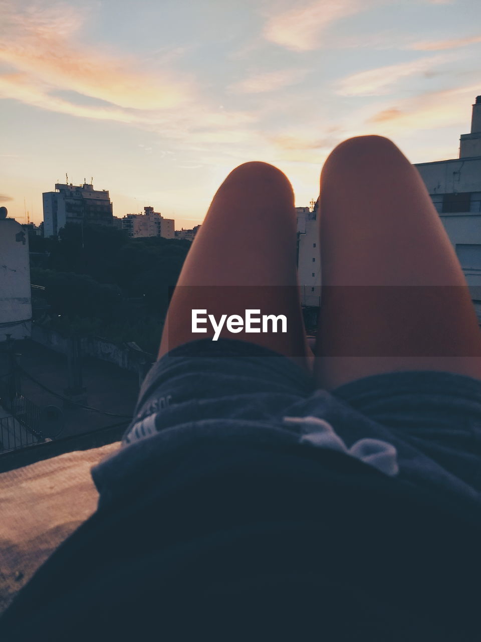 LOW SECTION OF MAN AND WOMAN RELAXING ON CITY