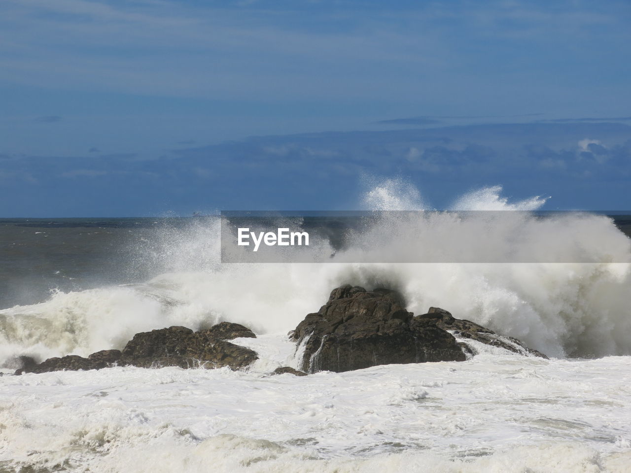 WAVES SPLASHING ON ROCKS AGAINST SEA