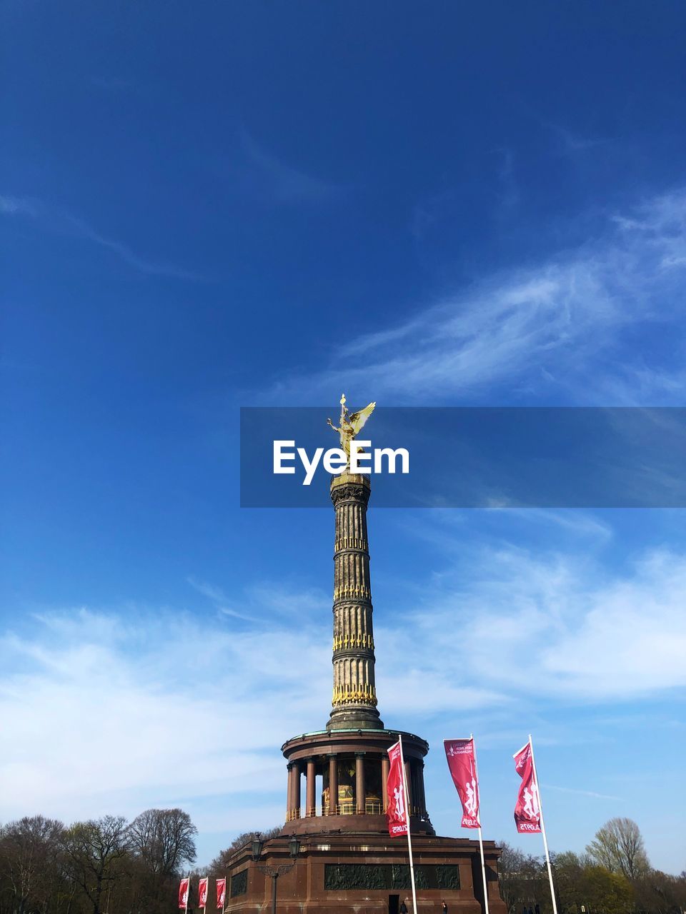 Low angle view of siegessäule in berlin against cloudy sky