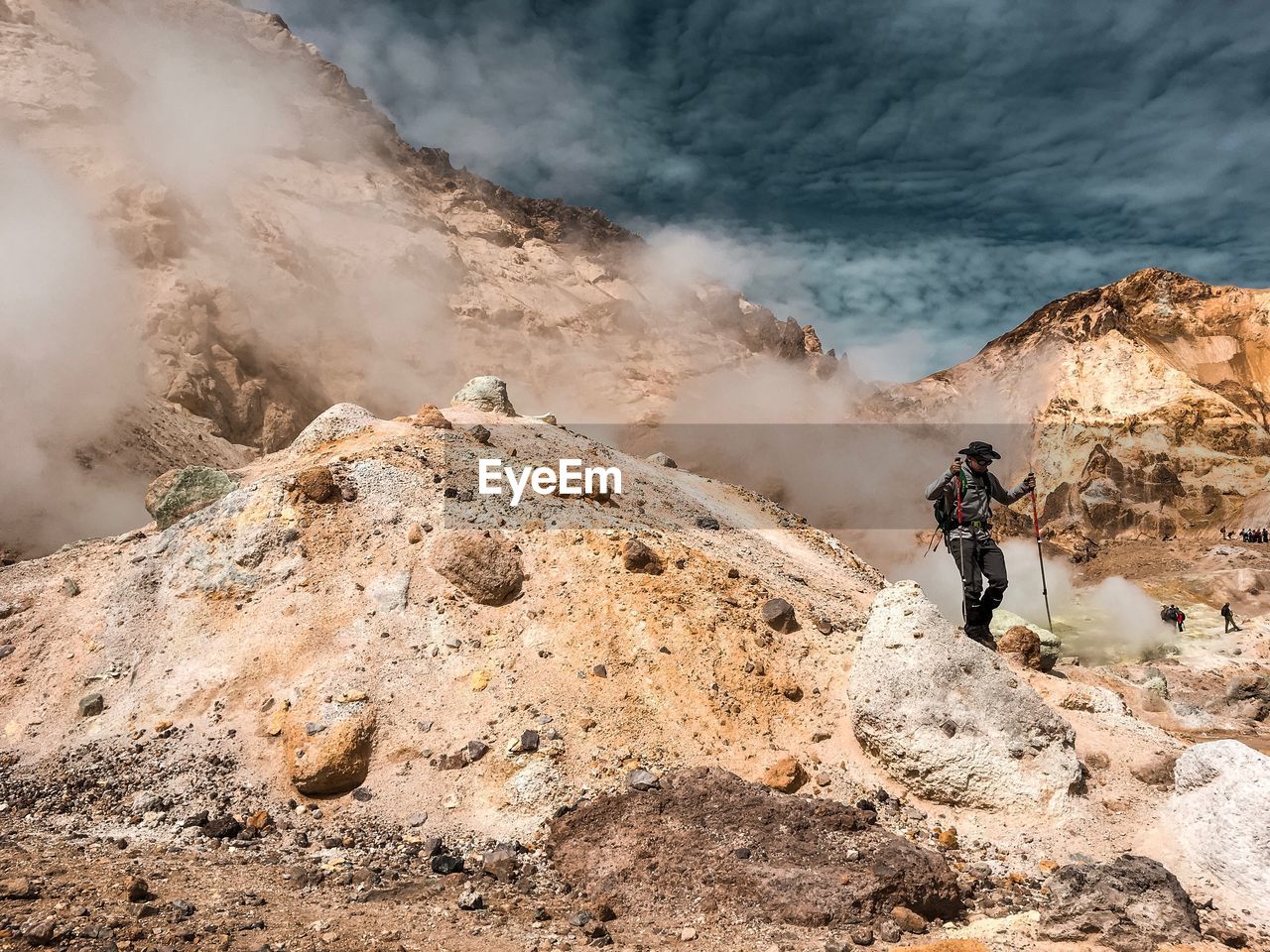 Man walking on rock against sky