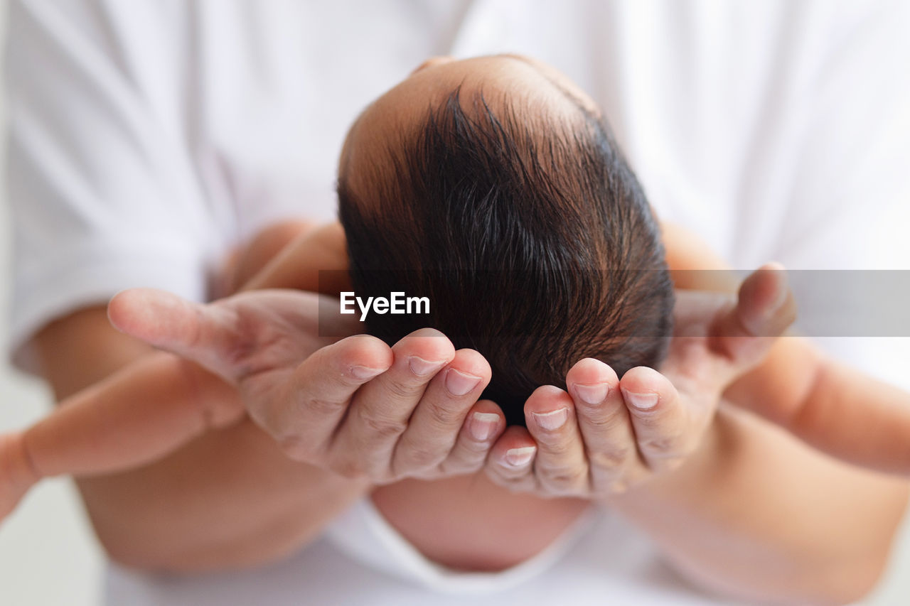 Midsection of woman holding newborn baby