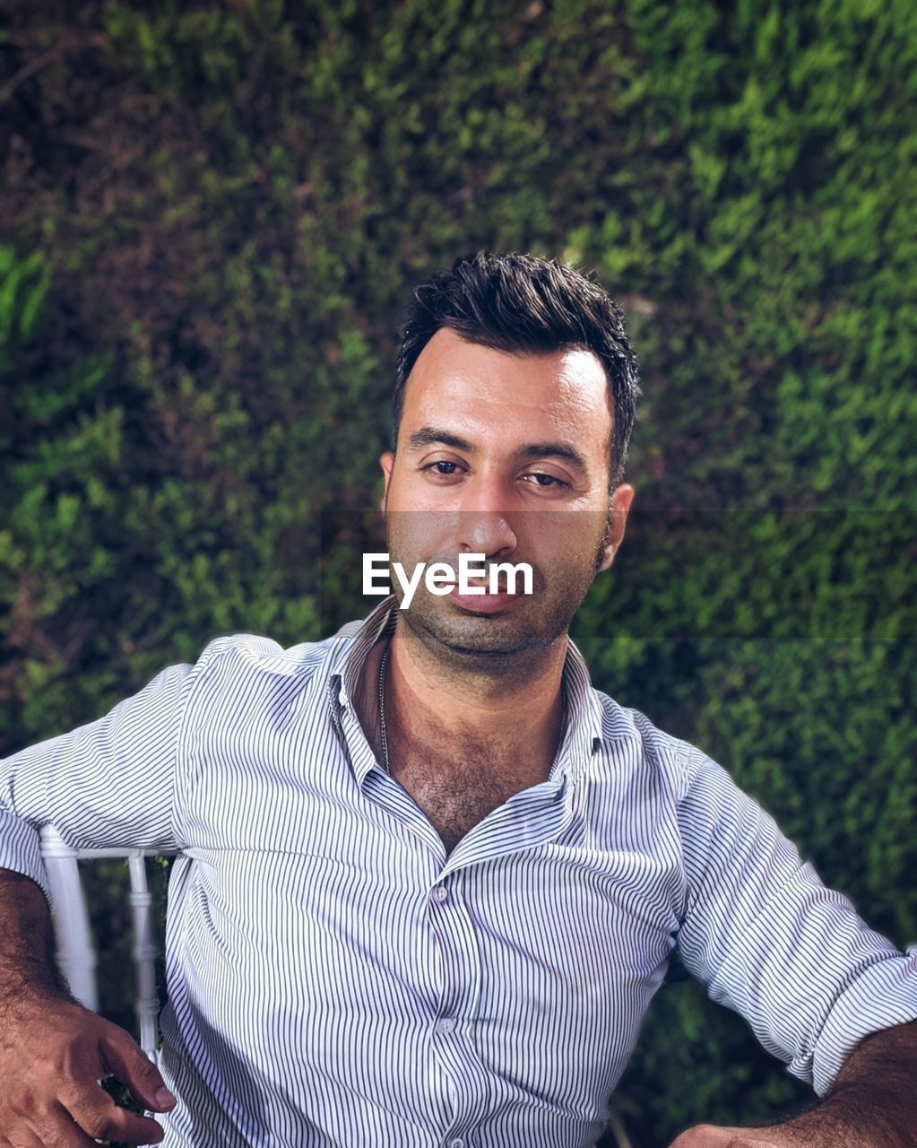 PORTRAIT OF HANDSOME MAN STANDING AGAINST PLANTS