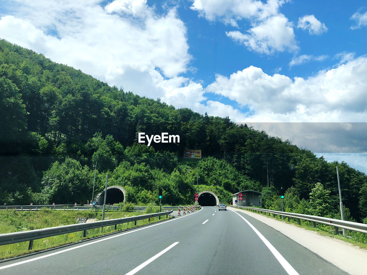 ROAD AMIDST PLANTS AND TREES AGAINST SKY