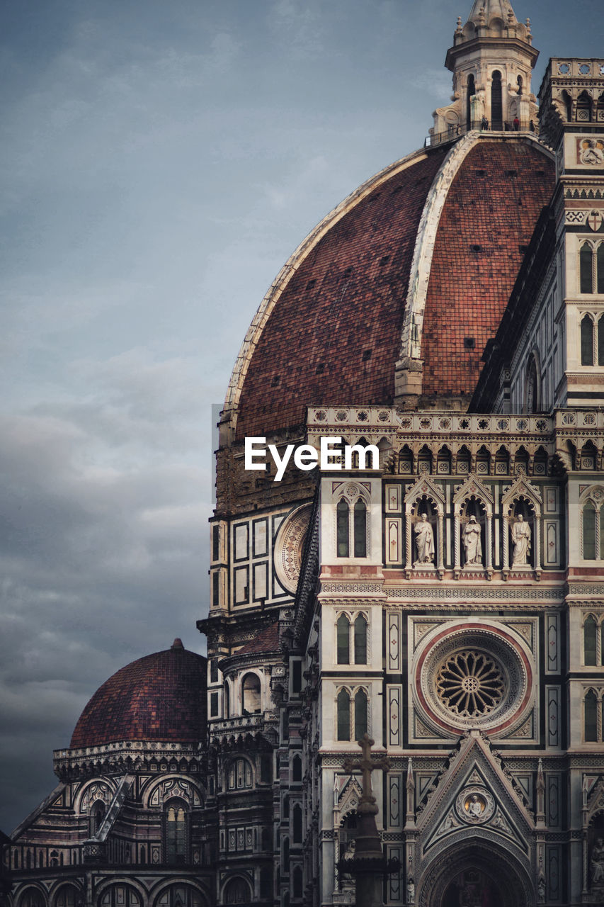 Low angle view of florence cathedral against cloudy sky