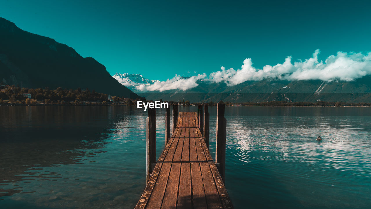 Pier over lake against blue sky