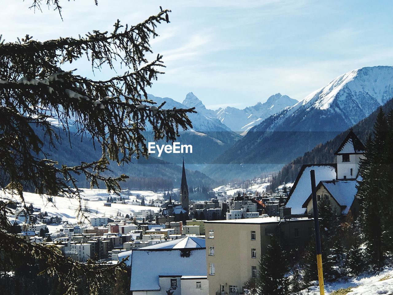 Houses and snowcapped mountains against sky