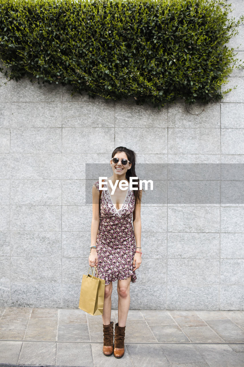 Happy young woman holding shopping bag