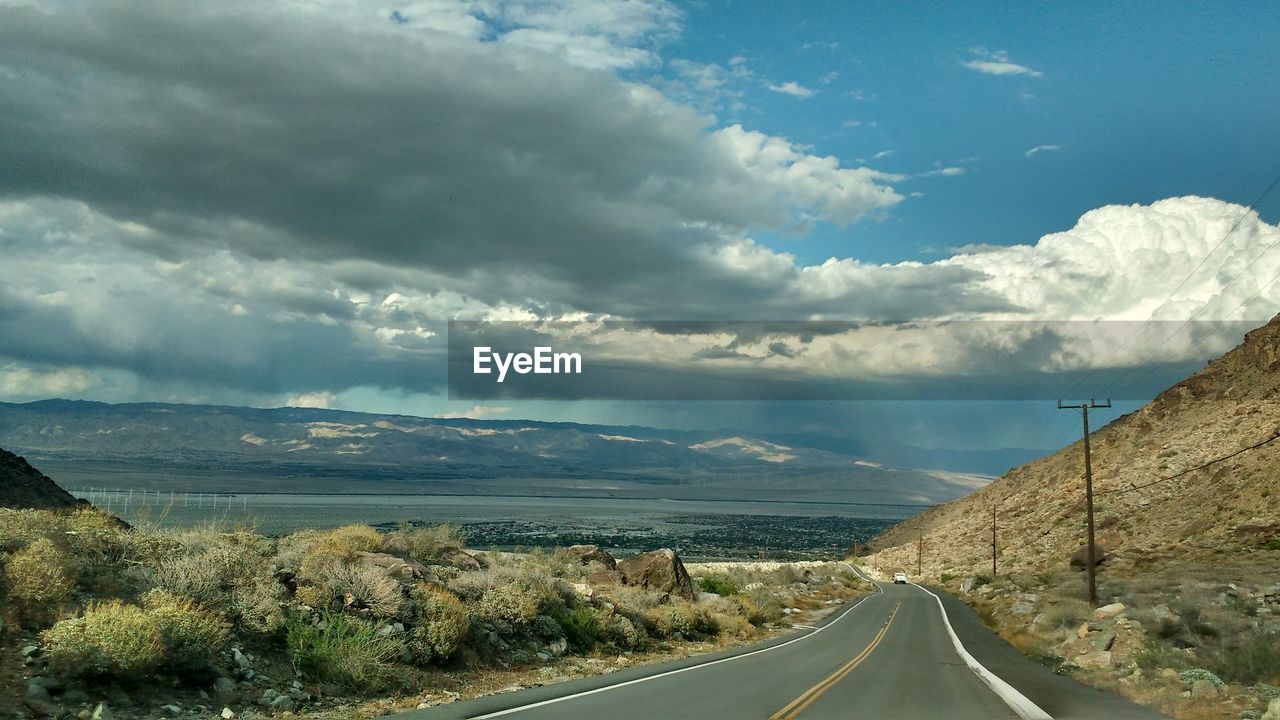 Empty road along countryside landscape