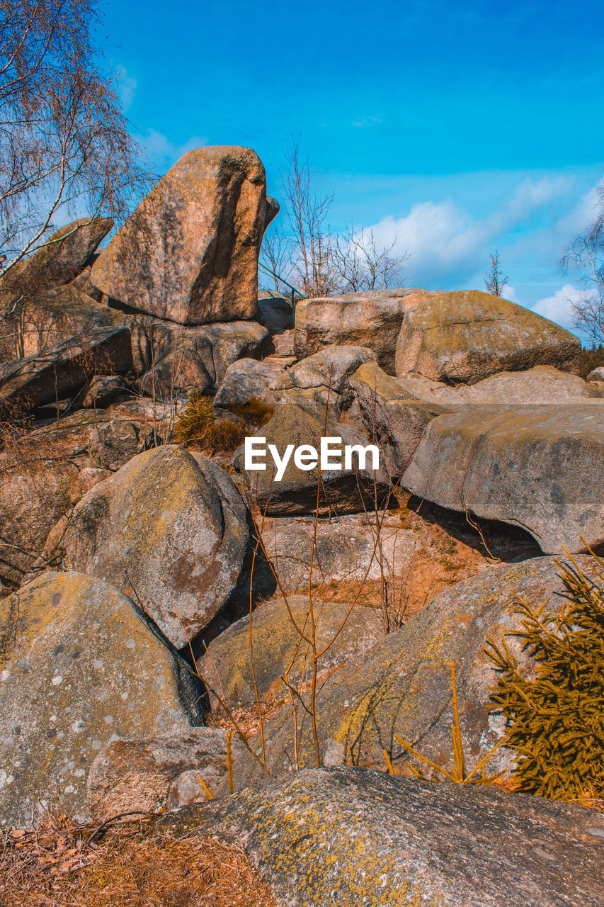 LOW ANGLE VIEW OF ROCK FORMATION AGAINST BLUE SKY