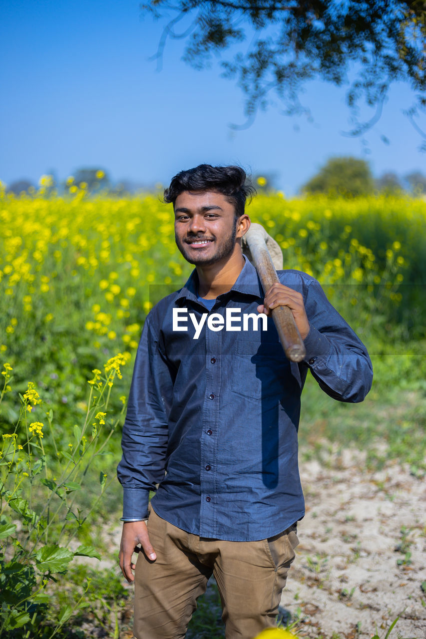 Portrait of smiling teenager standing in farm