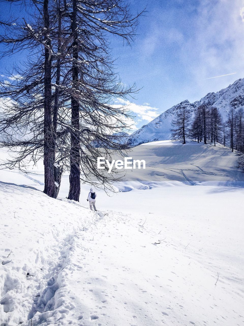 Scenic view of snow covered mountains against cloudy sky