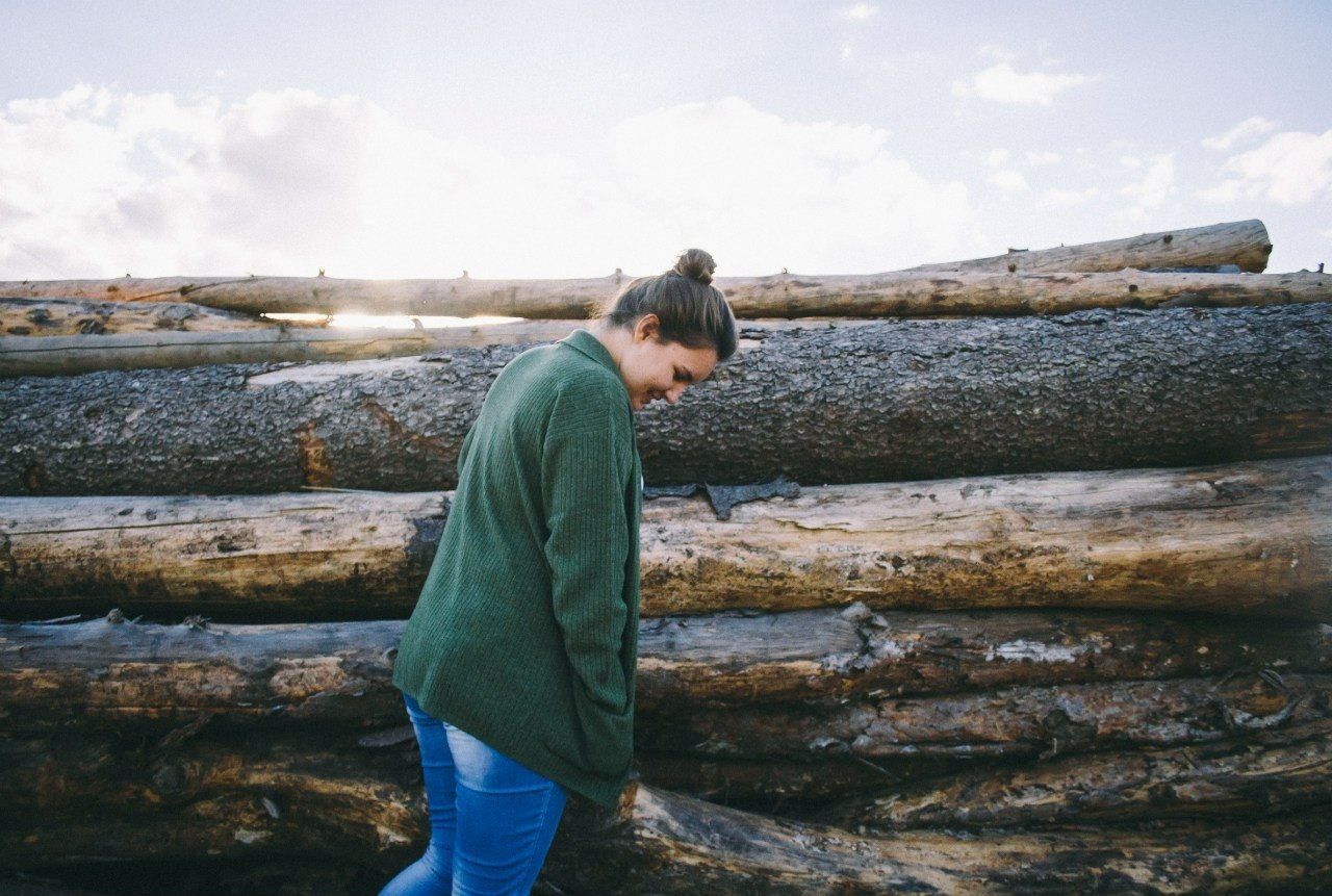 Woman standing near logs