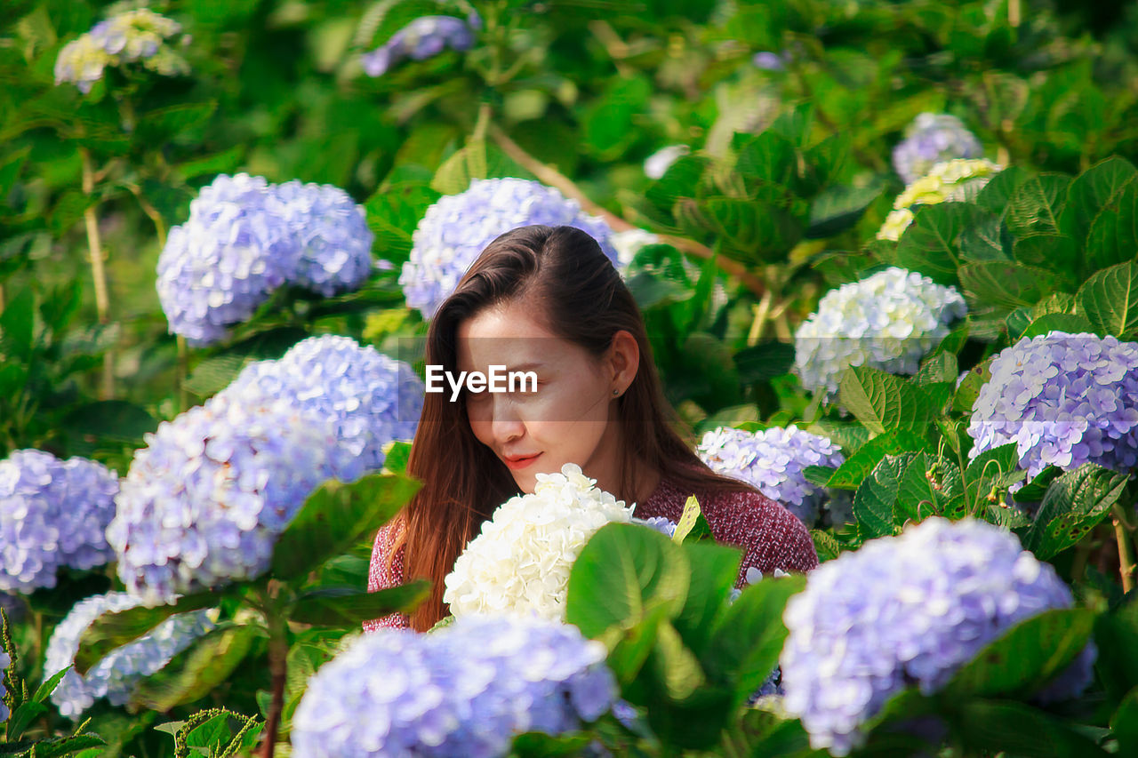 Smiling woman by flowering plants