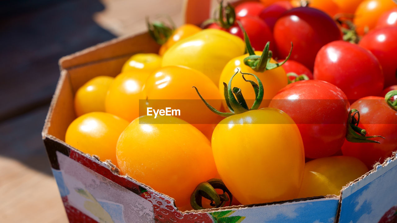 food, food and drink, healthy eating, tomato, vegetable, freshness, container, fruit, wellbeing, produce, plant, red, yellow, no people, large group of objects, box, multi colored, crate, abundance, close-up, indoors, retail, still life