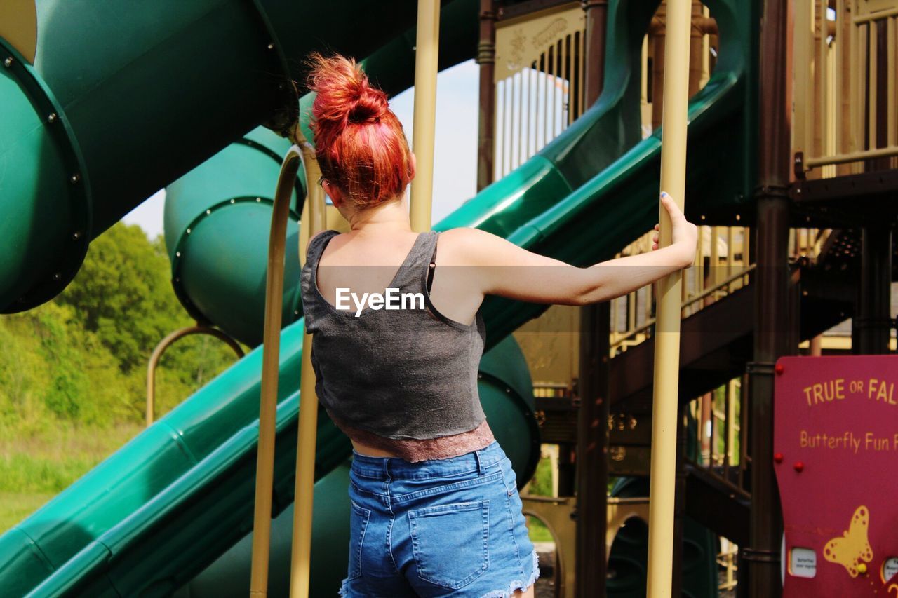 Rear view of woman playing at playground