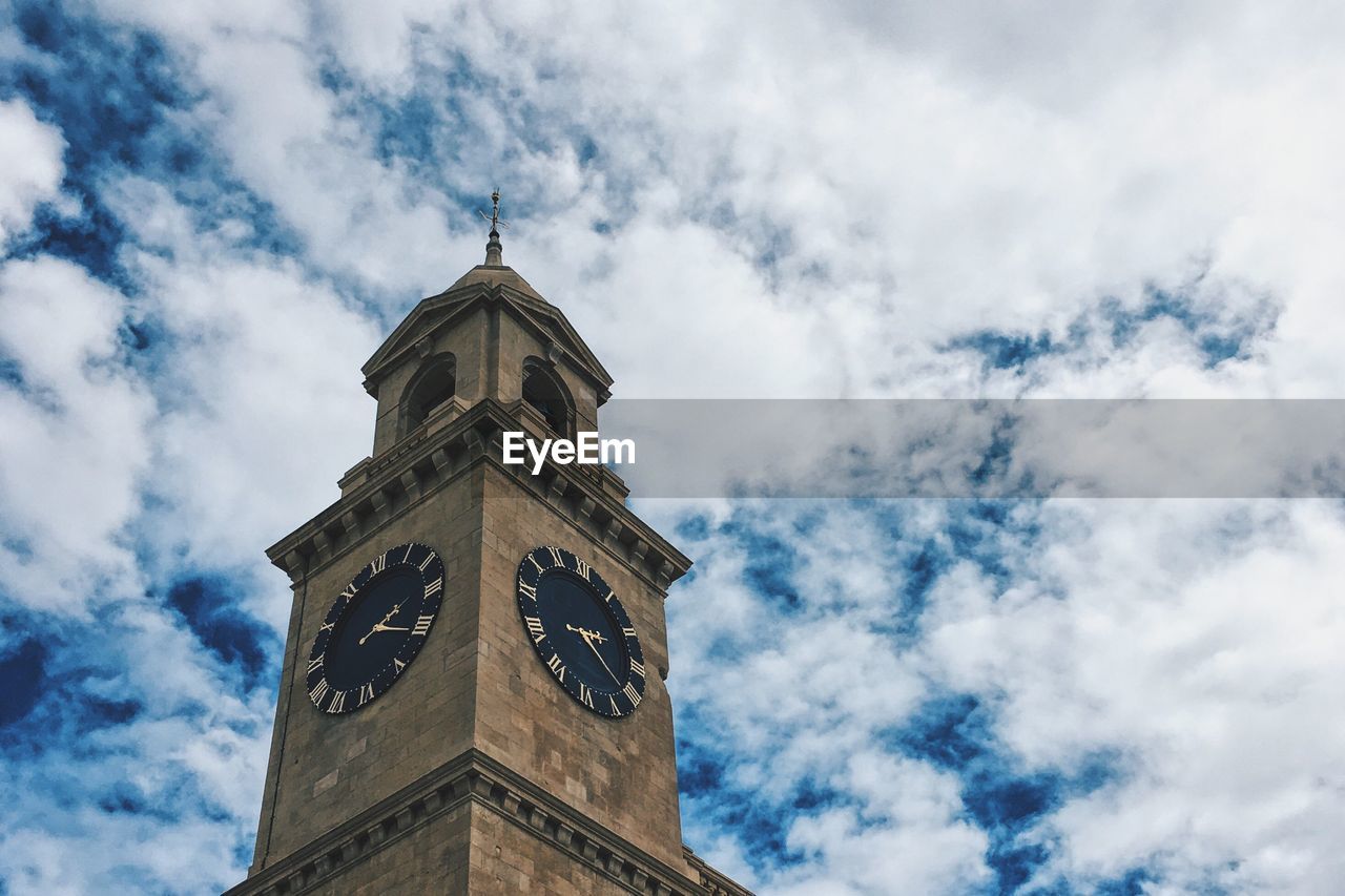 Low angle view of clock tower against cloudy sky