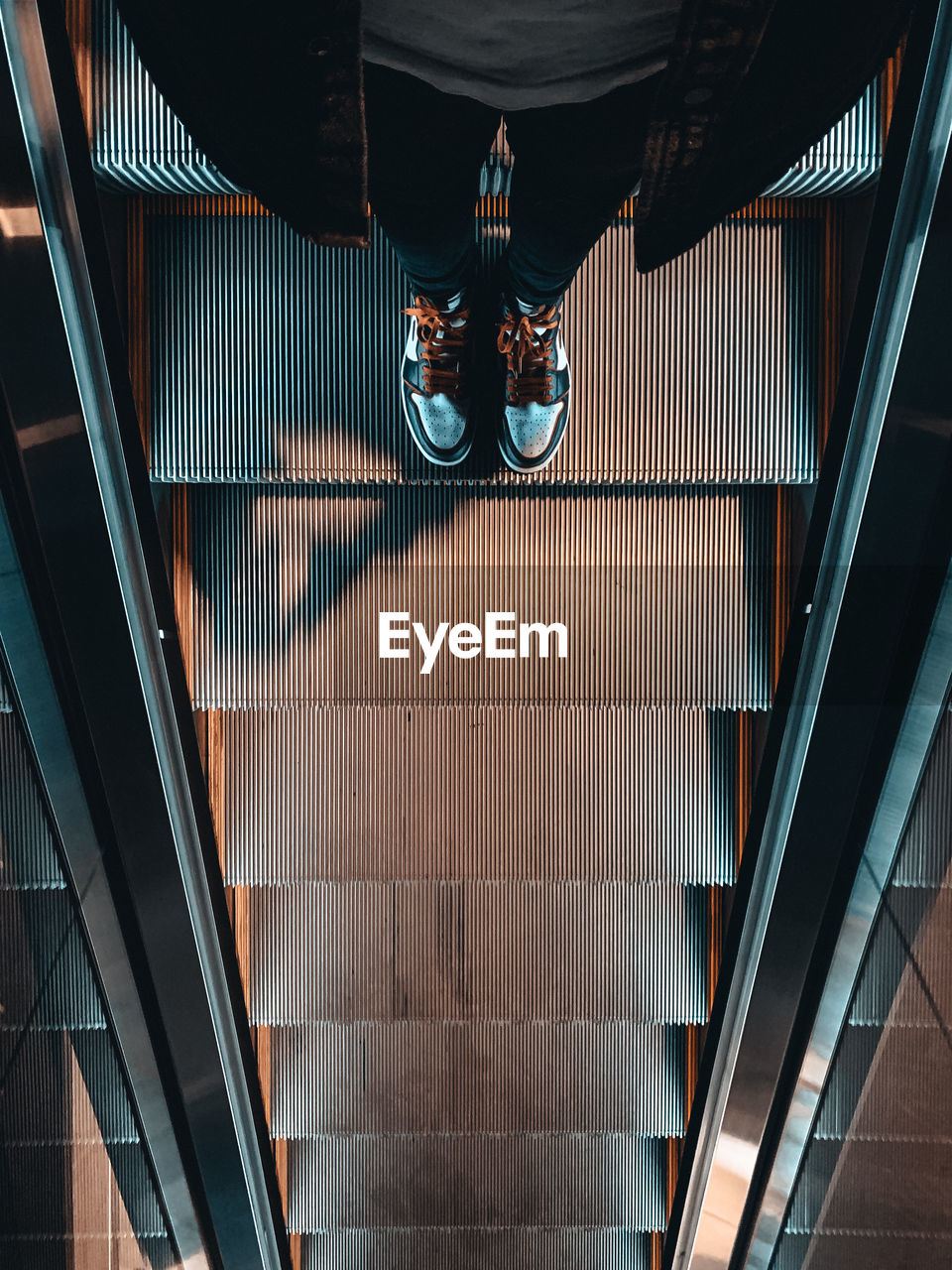 Low section of man standing on escalator