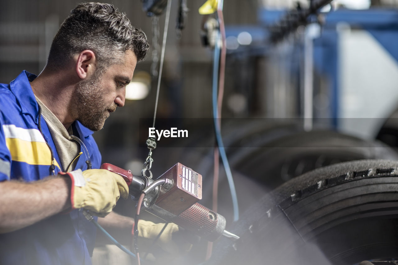 Repairman working on tire in factory