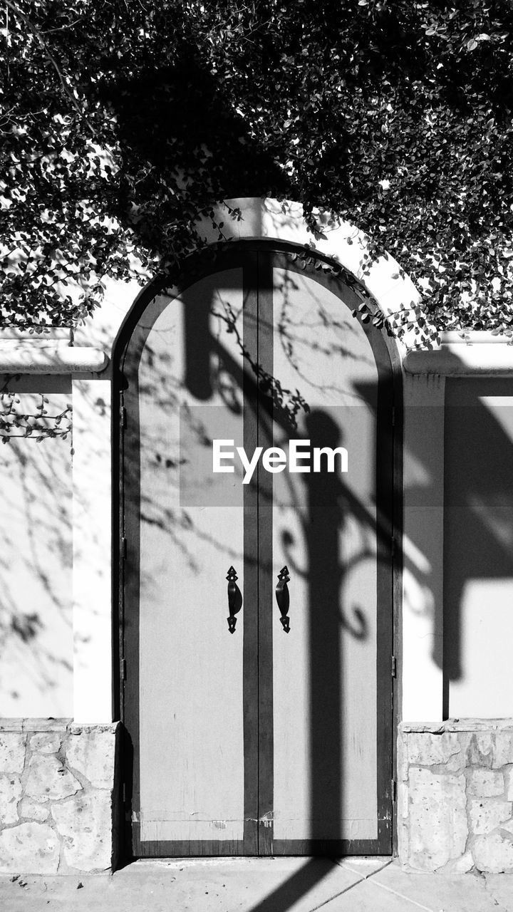 LOW ANGLE VIEW OF GATE AGAINST TREES AND BUILDING