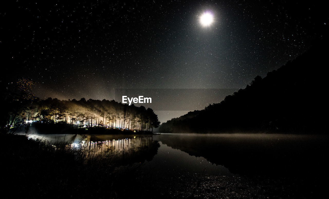 Scenic view of lake against clear sky at night