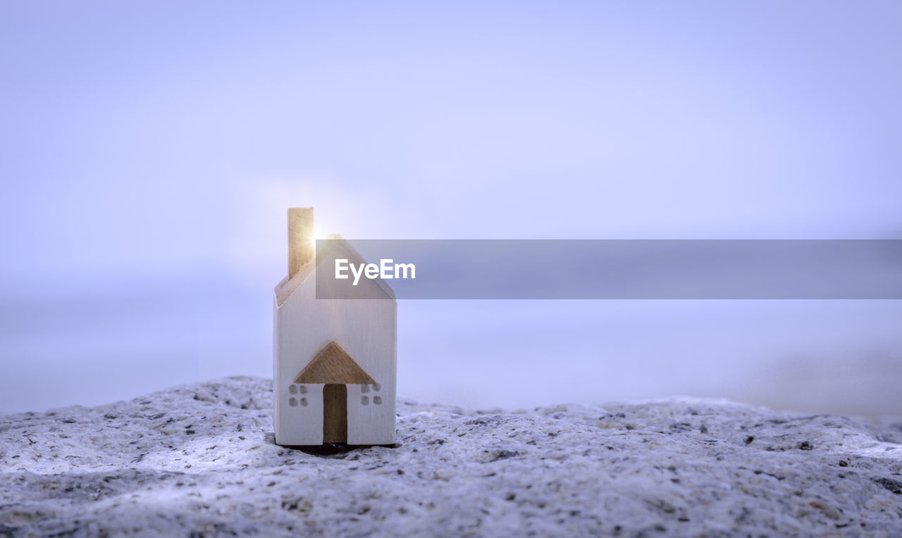 The miniature white house on stone with background of sea beach. family lifestyle and building