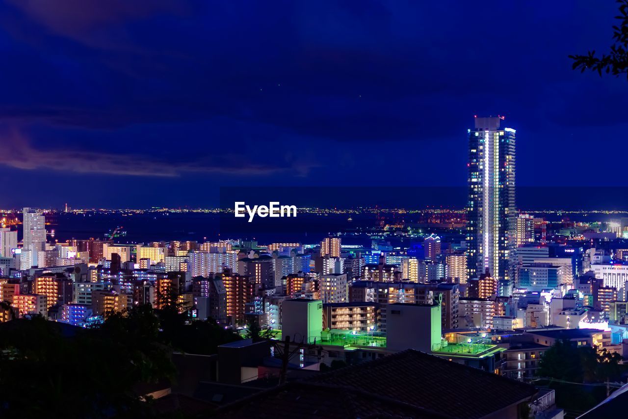 High angle view of illuminated buildings against sky at night