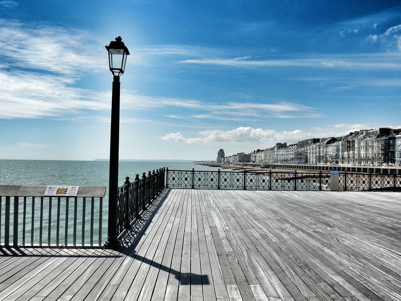 Street light by sea against sky