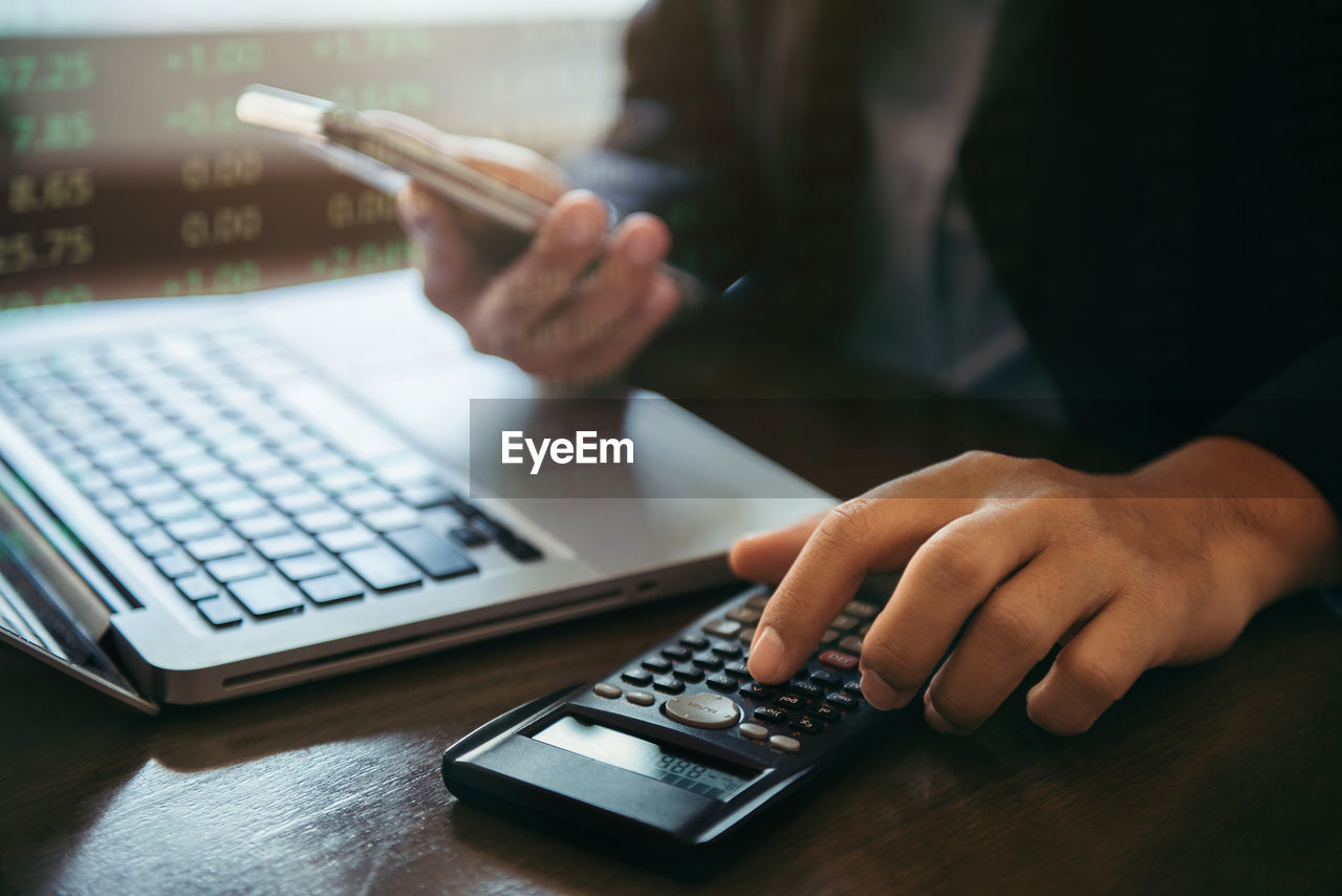 midsection of man using laptop on table