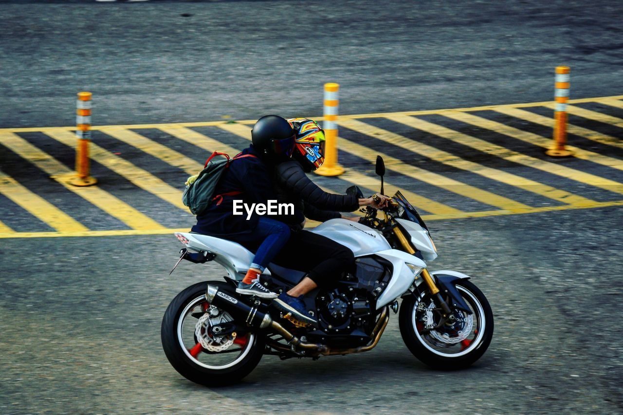 REAR VIEW OF MAN RIDING MOTORCYCLE AT WATER