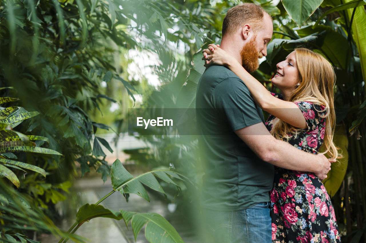 Romantic girlfriend and boyfriend embracing each other in park