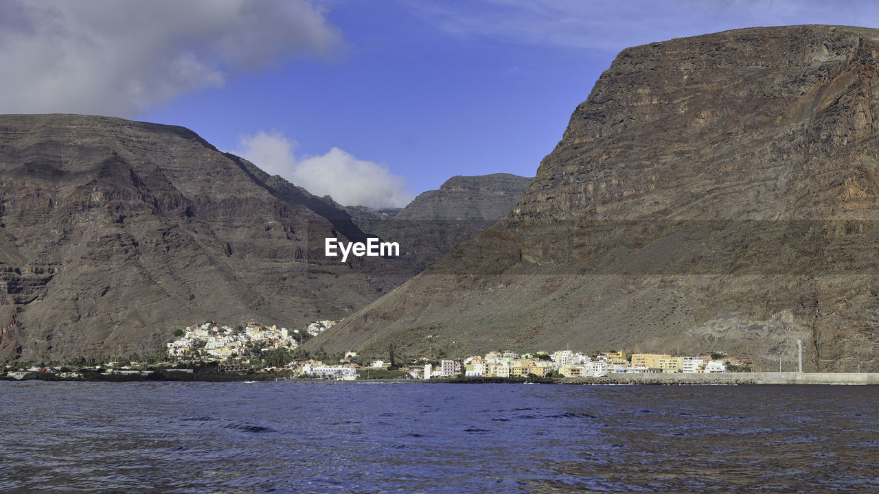 Scenic view of sea and mountains against sky