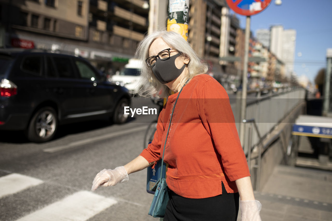 Woman wearing face mask while walking at street