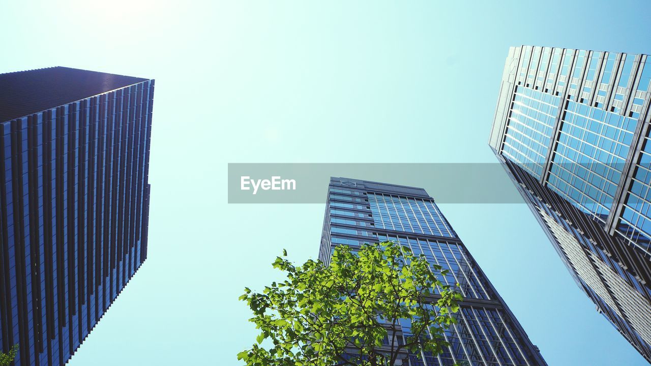 Low angle view of modern buildings in city against clear sky