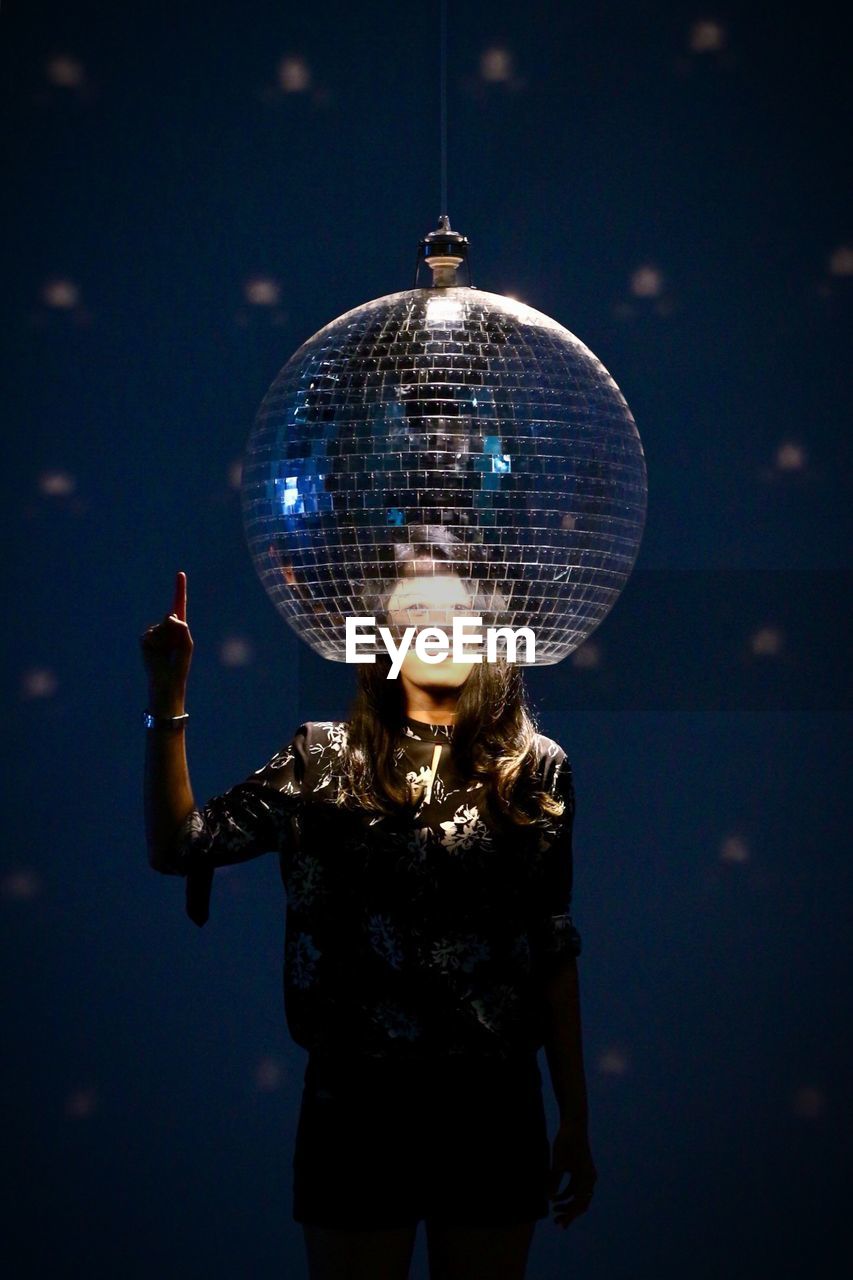 Woman standing under spherical light