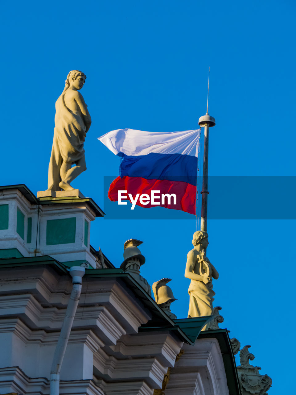 LOW ANGLE VIEW OF STATUE AGAINST BUILDINGS AGAINST CLEAR BLUE SKY