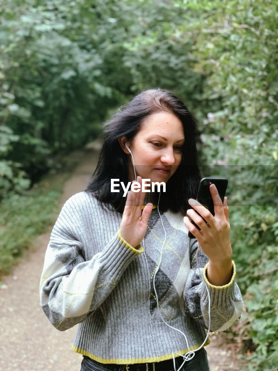 Young woman is walking in the park and talking to her friends with using video call.casual lifestyle